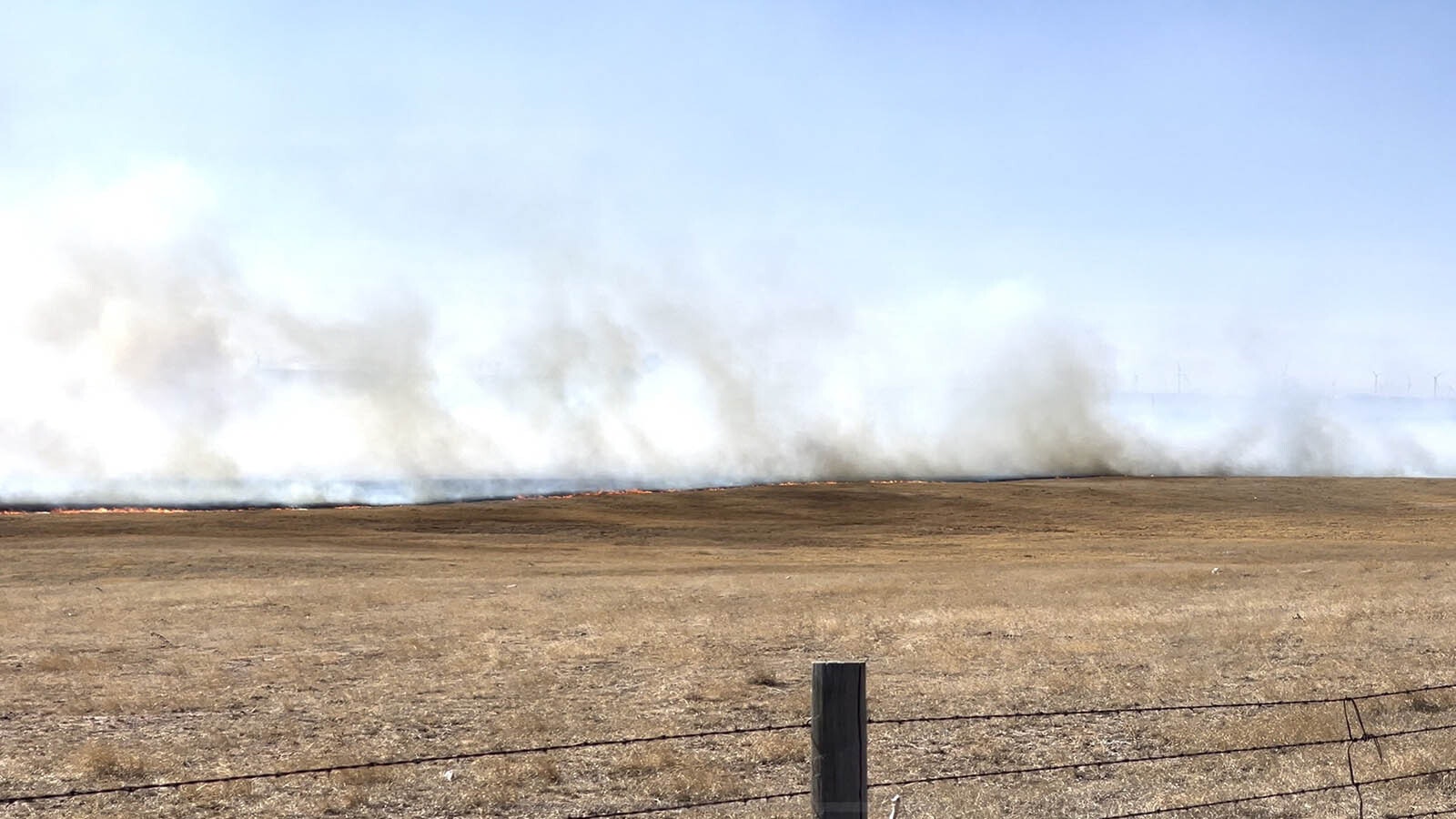 Flames from a fast-moving grass fire jumped Interstate 80 just west of Cheyenne on Saturday, driven by winds gusting more than 65 mph.