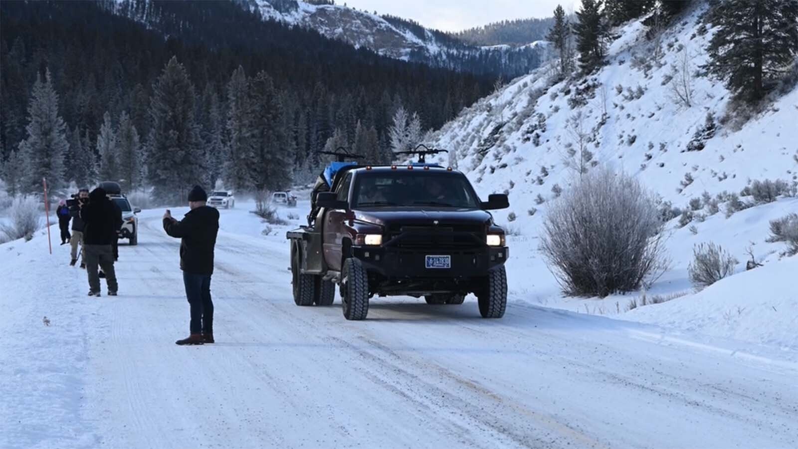 Tourists piling out of tour van parked in the middle of the road in Yellowstone National Park, which is against park rules. They also park in the flow of traffic.