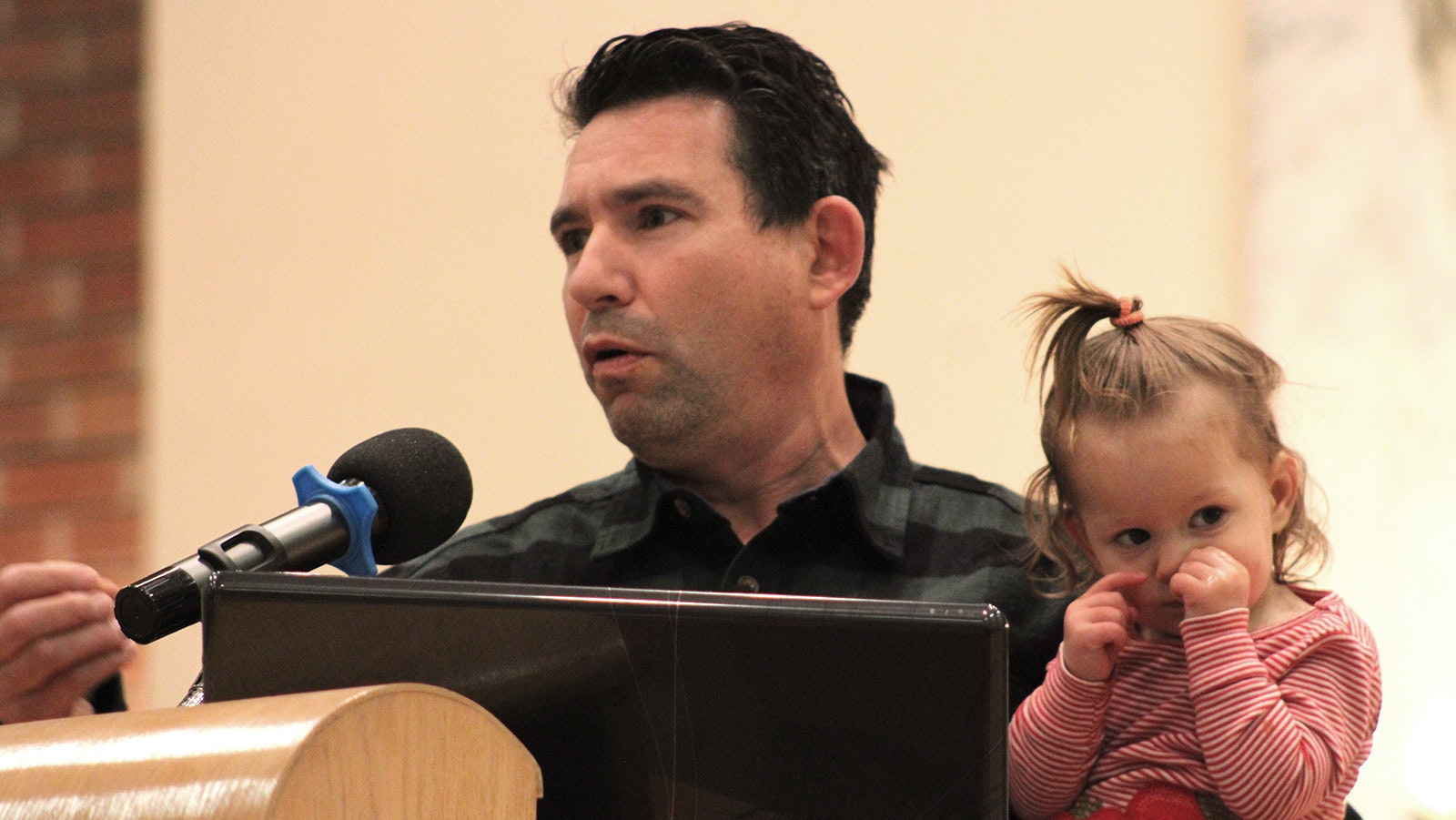 Noam Mantaka, with his young daughter, speaks at a Monday interfaith plea for peace in Cheyenne.