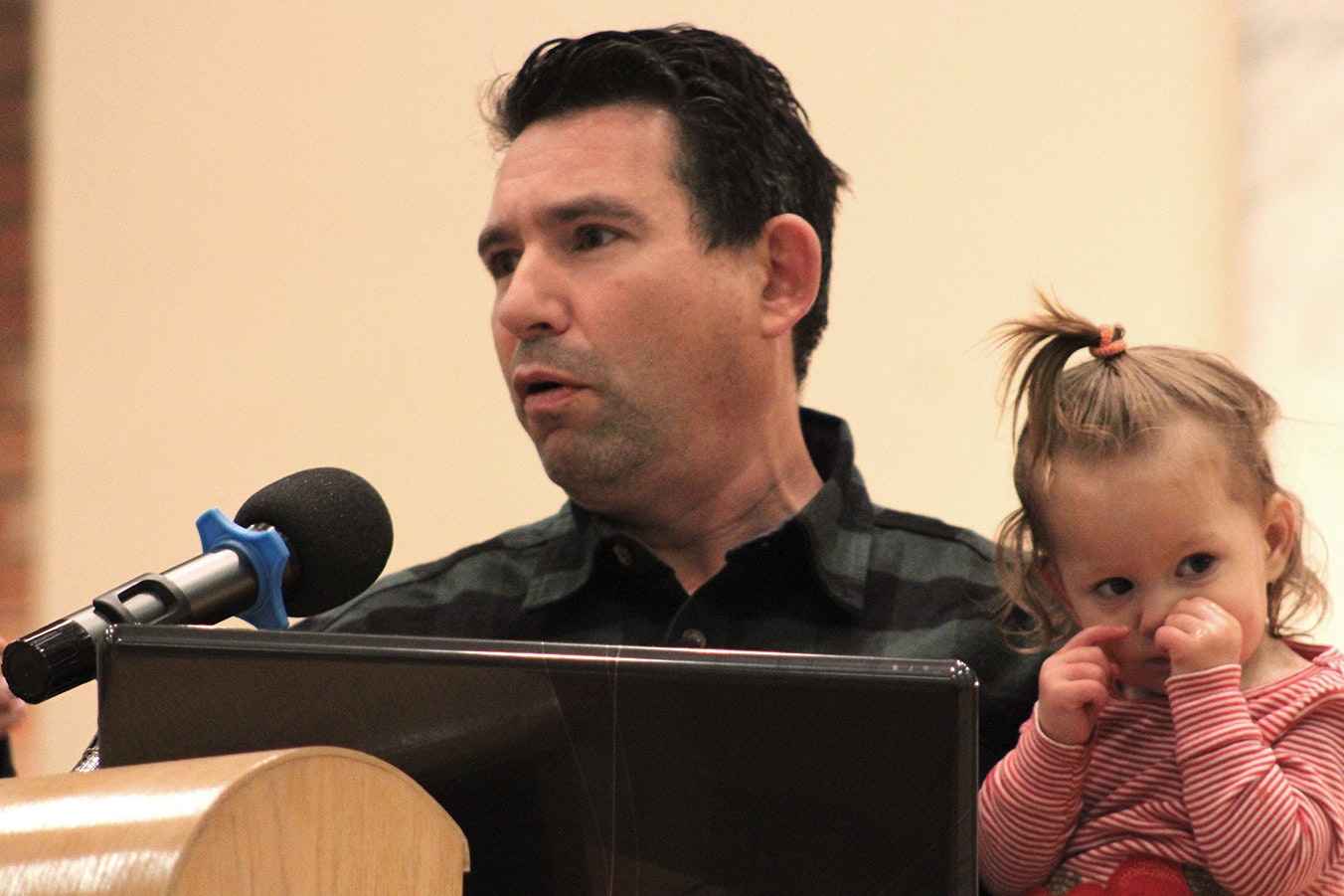 Noam Mantaka, with his young daughter, speaks at a Monday interfaith plea for peace in Cheyenne.