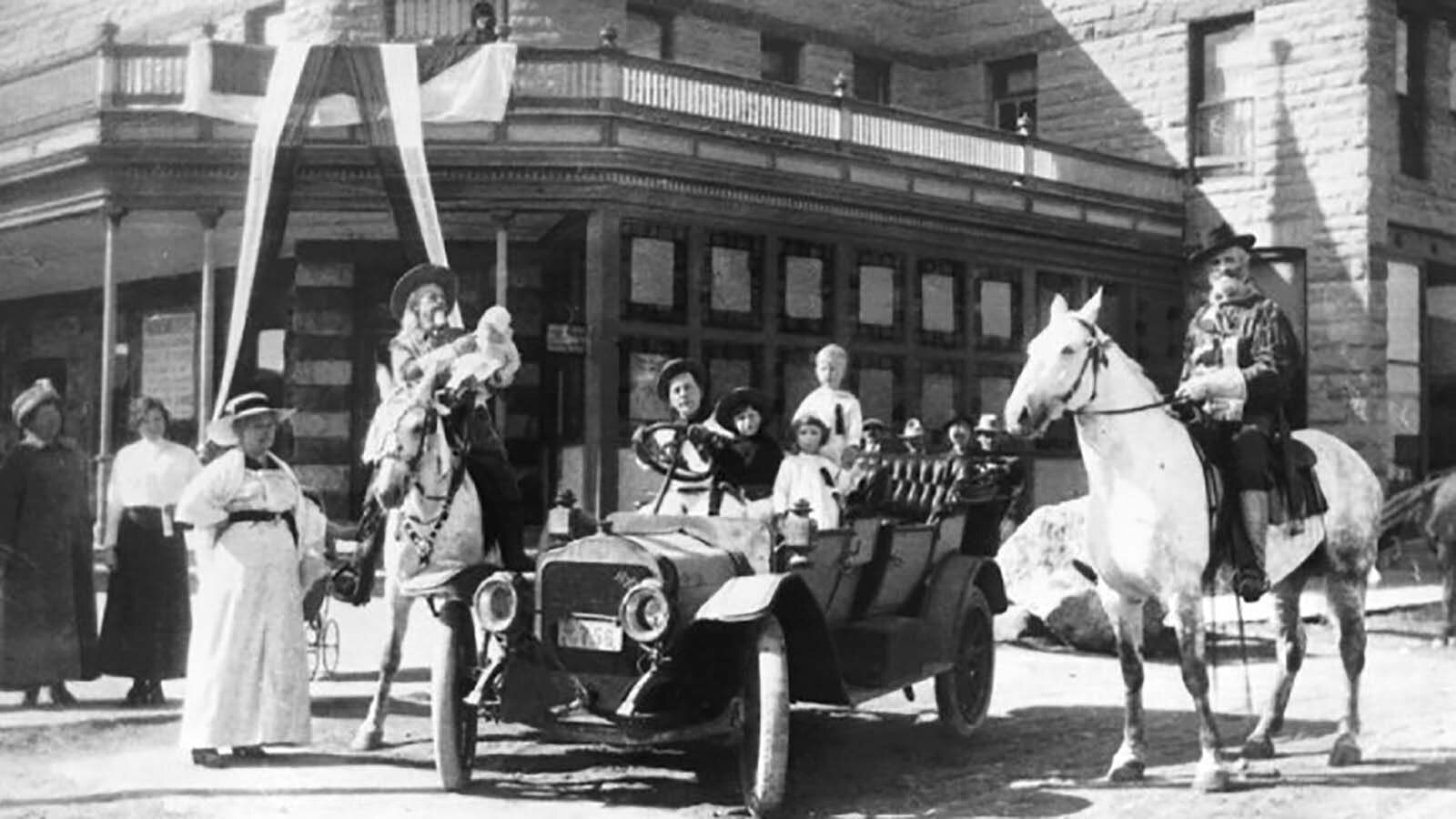 Buffalo Bill Cody on horseback, second from left, in front of The Irma Hotel.