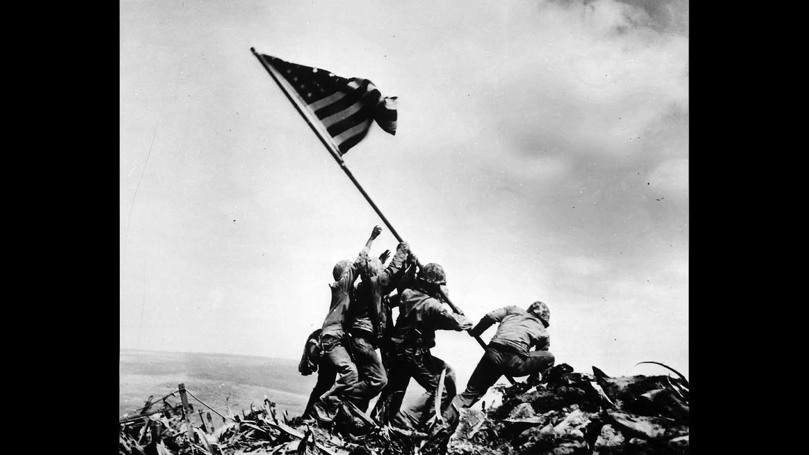 Members of the U.S. Marine Corps raise an American flag atop Mount Suribatchi amid fighting during World War II with Japan, on Feb. 23, 1945. They are Cpl. Harlon Block, Pfc. Harold Keller, Pfc. Franklin Sousley, Sgt. Michael Strank, Pfc. Harold Schultz and Pfc. Ira Hayes.
