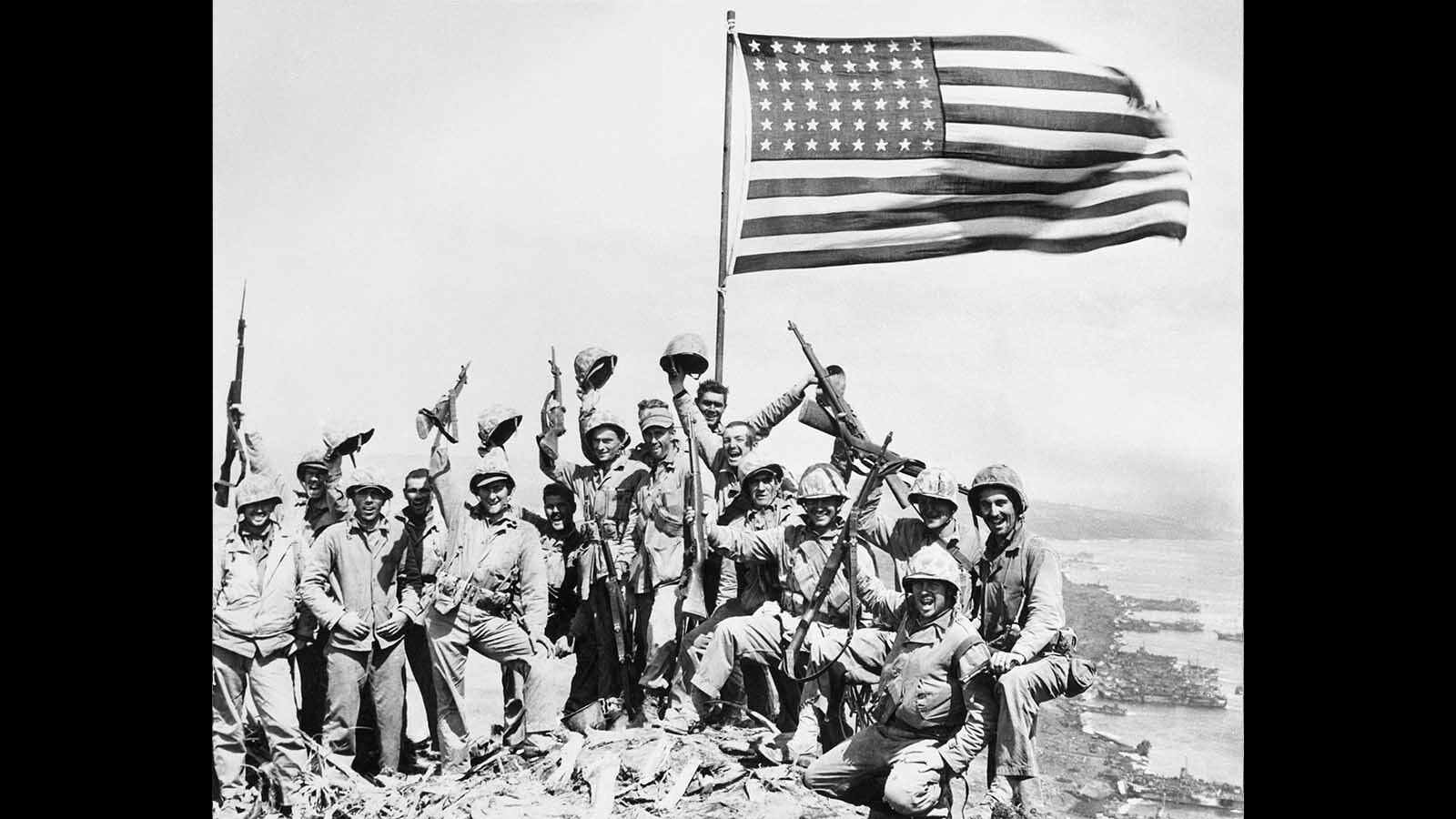 U.S. Marines pose on top of Mount Suribachi on the island of Iwo Jima with the American flag (cropped version). They are, from left, (cropped out Ira Hayes, John R Thurman), Harold George Schrier, Franklin R. Sousley, Michael Strank, John H. Bradley, Clarence H. Garrett, Graydon W. Dyce, Howard M. Snyder, Henry O. Hansen, Harlon Henry Block, (behind Hansen with only part of his head visible), Philip L. Ward, Fred J. Walzak, Harold Henry Schultz, Harold P. Keller, Thomas J Hekmanek, Jr, Raymond H. Larsen and John T. Schmitt.
