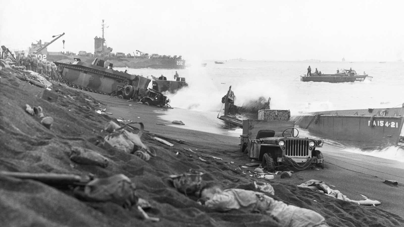 This scene partially depicts the desperate struggle of Marine forces to establish a toehold on Iwo Jima in the Volcano Islands. The Leatherneck in the foreground, killed in the initial assault, is surrounded by lost equipment and the wreckage of many types of craft and vehicles. In the early stages of the battle, most of the mobile units were bogged down in the soft volcanic ash covering the island.