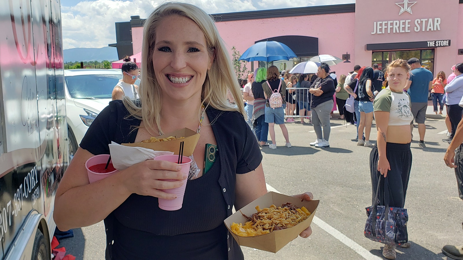 A friend held her place in line so Jenna Haworth could buy yak mac and cheese for them to eat while in line. They were still all the way back to the splash pad area of the line at midday.