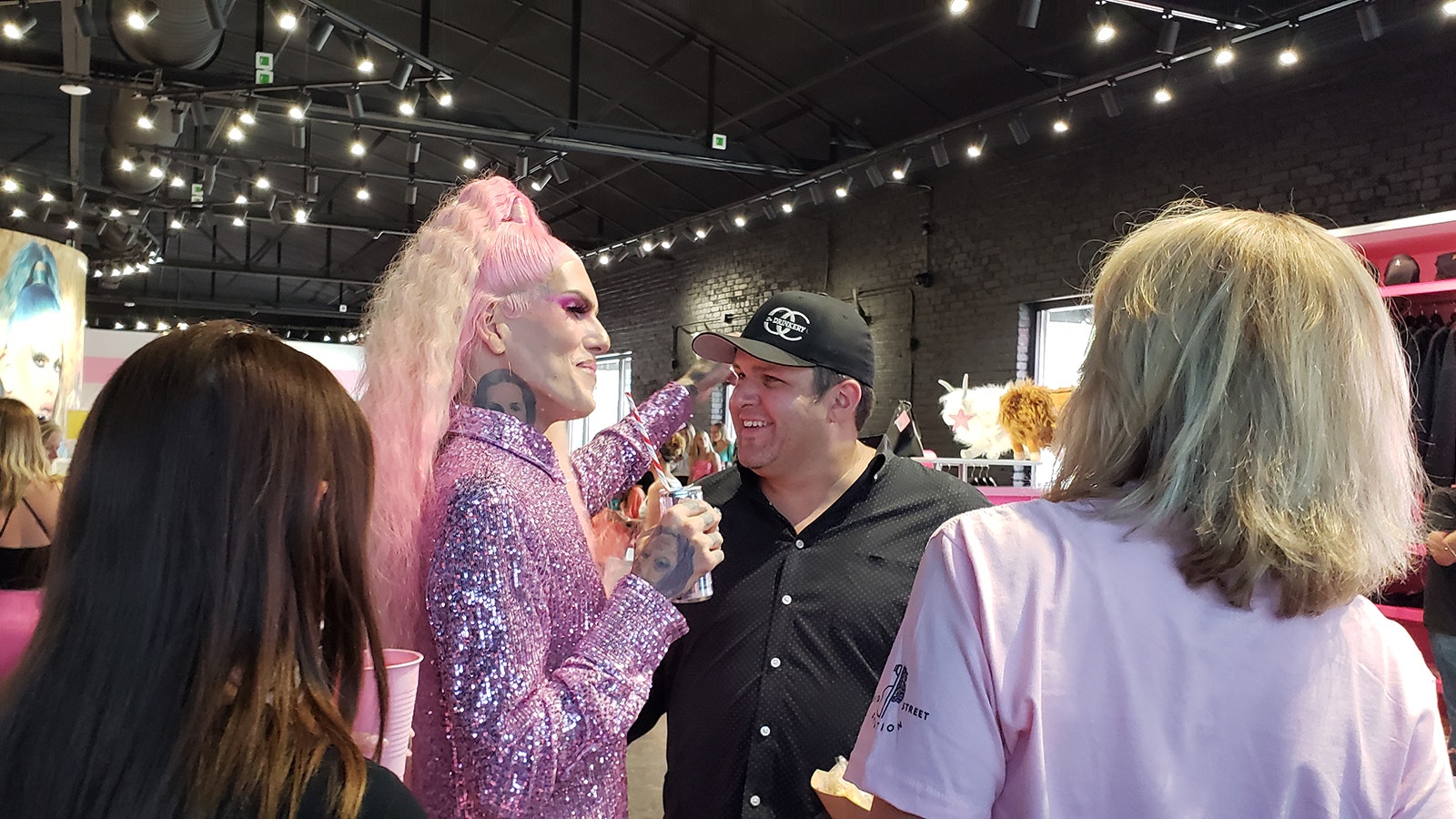 Jeffree Star hugs someone in his store while taking a break from photos with fans.