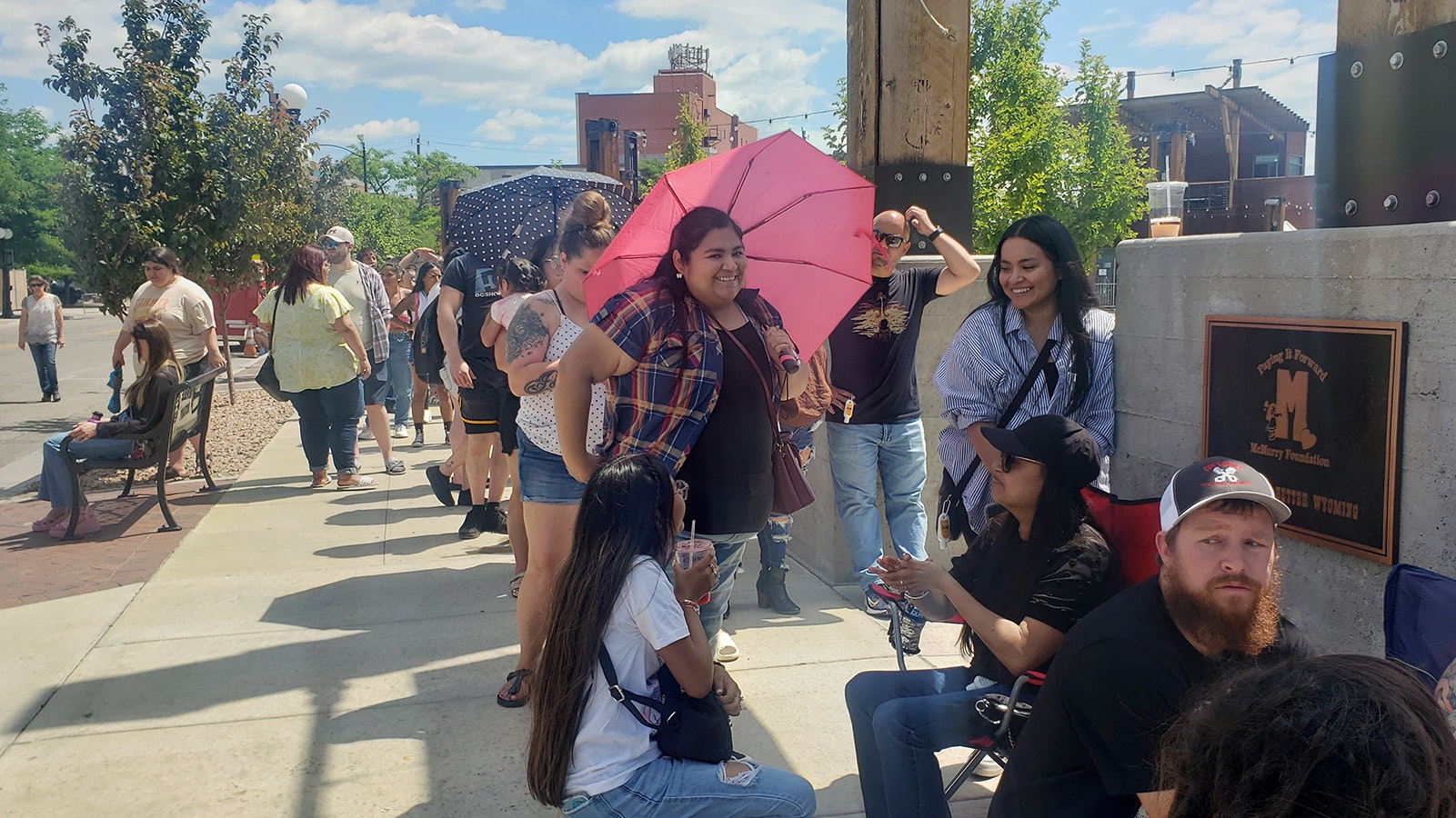Margarita Padilla with the pink umbrella stands in line with sister Eva back, right. Just ahead of them are cousin Tiffany Hinojosa and Hinojosa's mom, Ivette Pizarro.