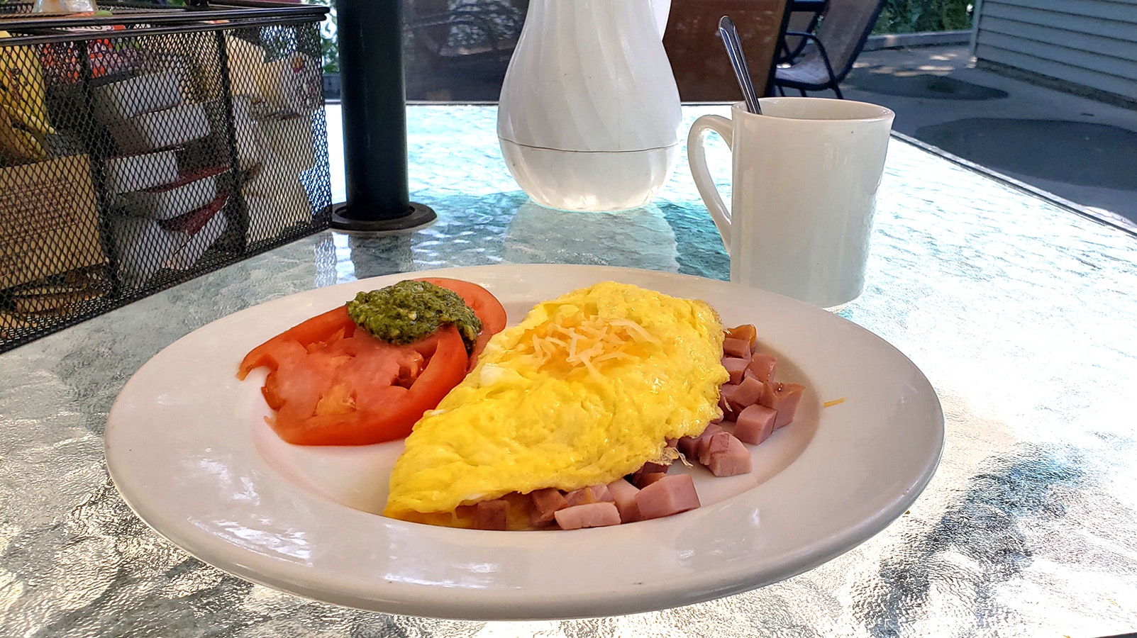 A ham, egg and cheese omelet with a side of tomatoes and basil and coffee at J.W. Hugus Restaurant & Catering.
