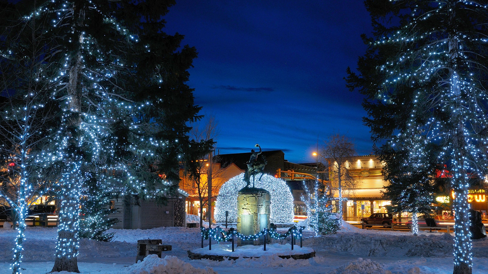 A dusting of snow covers Jackson Town Square in Wyoming as it's lit up during the holidays.