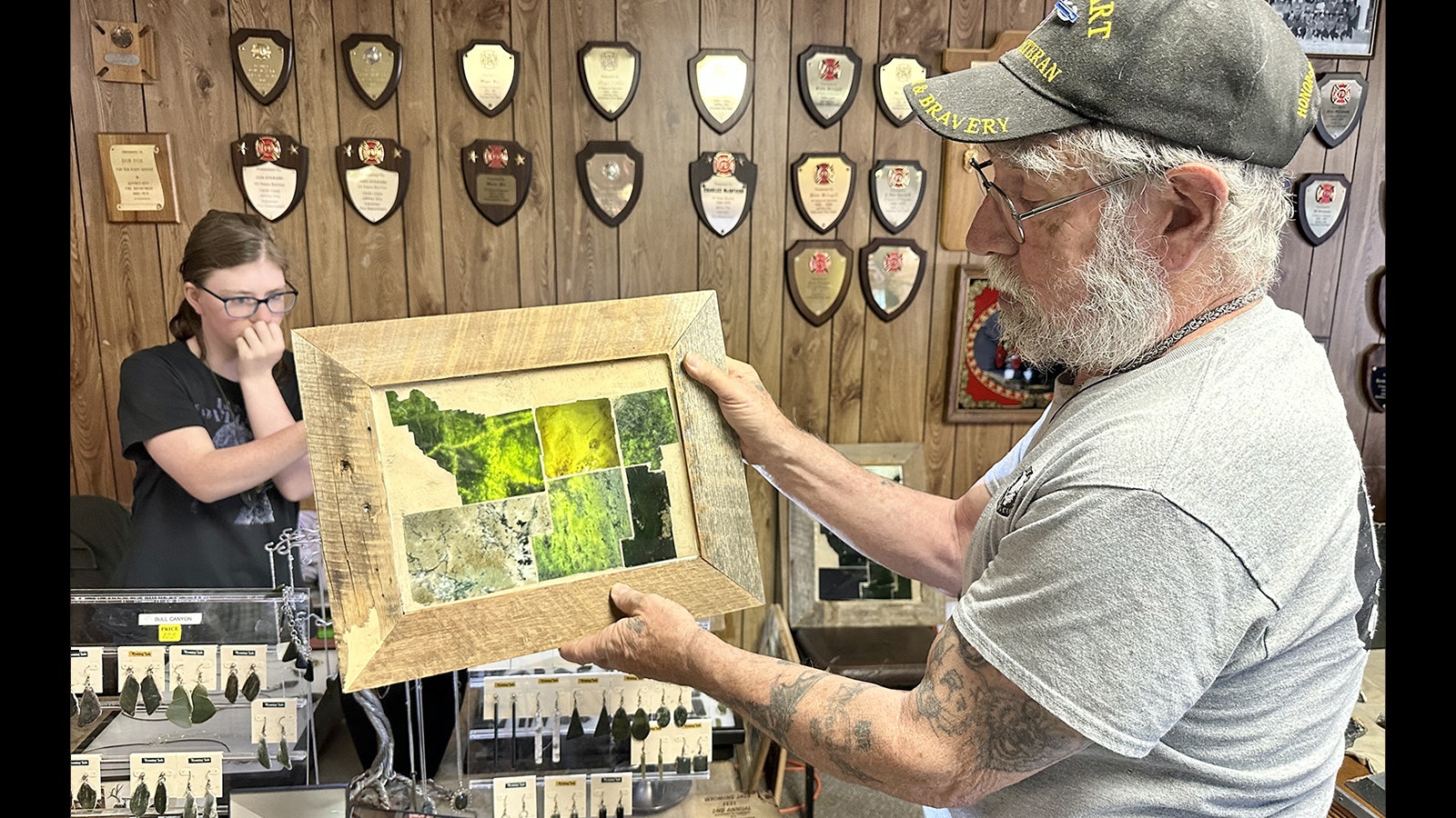 Mac Goss holds one of his jade maps of Wyoming while his daughter Heaven shines a flashlight from behind. Each county on the map is made from a different type of Wyoming jade found in that area.