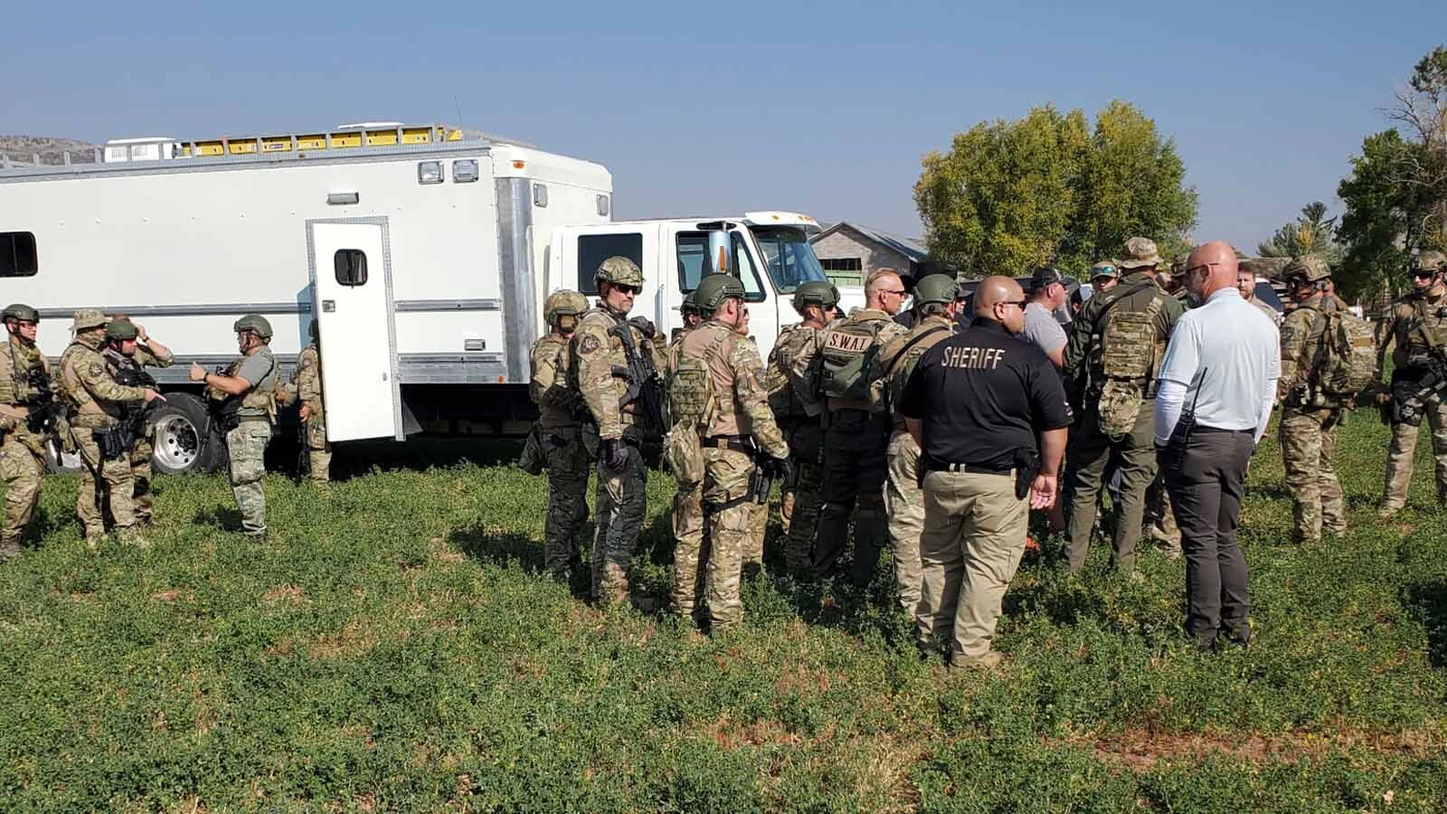 SWAT officers, sheriff's deputies and investigators gather at a mobile command post during the Utah operation.