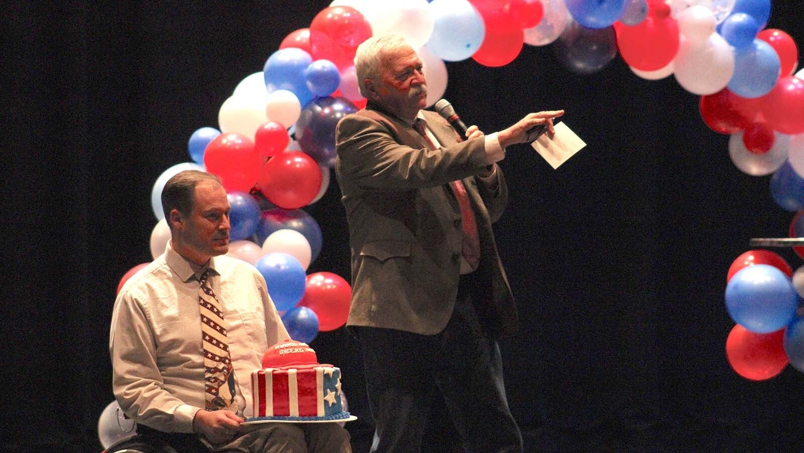 Campbell County GOP Chair Scott Clem, left, and Wyoming GOP Vice Chair David Holland auction off a MAGA cake that sold for $290.