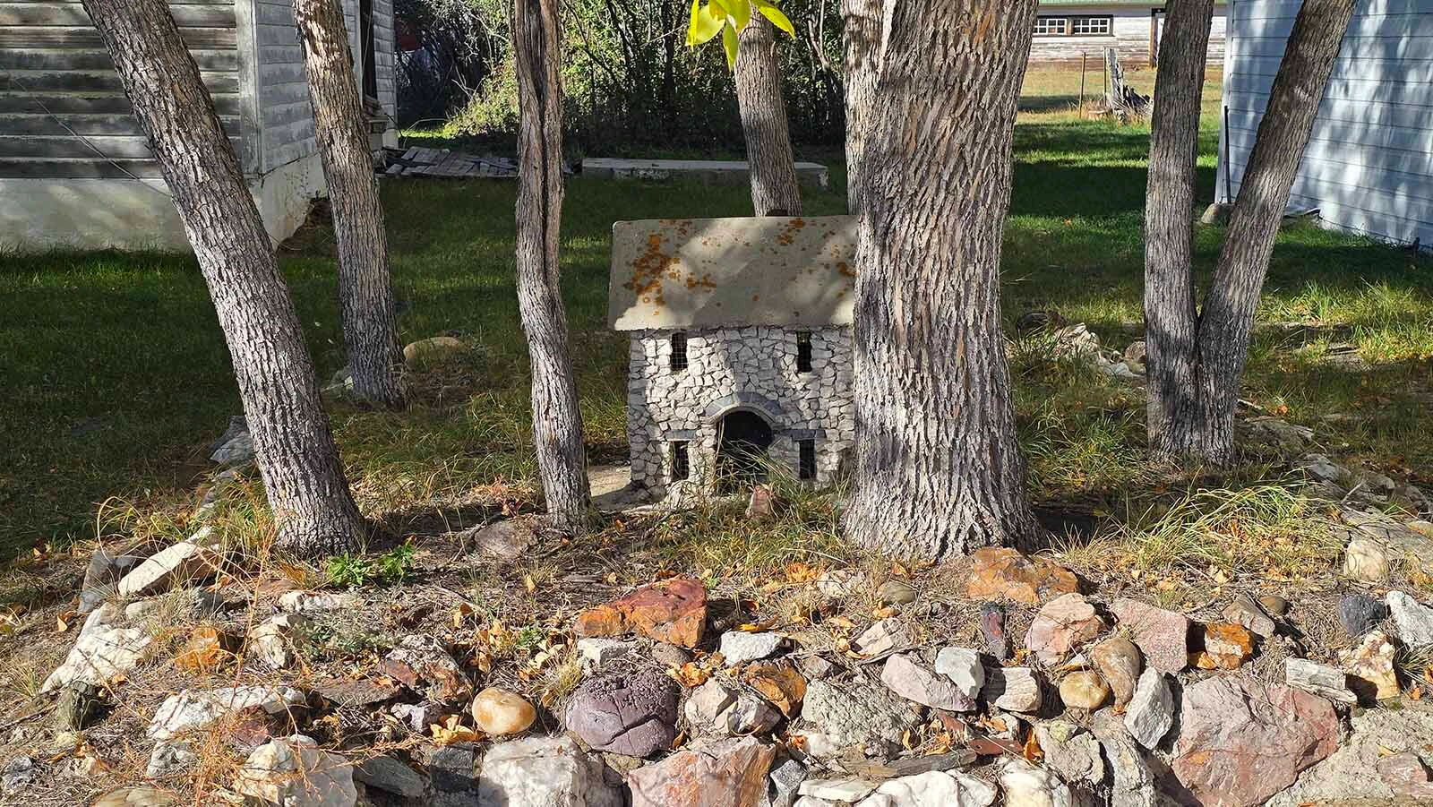 A tiny little house in a ring of trees in Jay Em.