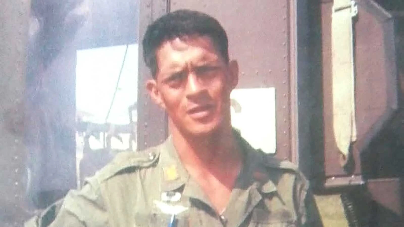 Jerry Montoya standing next to his chopper on a flight line.