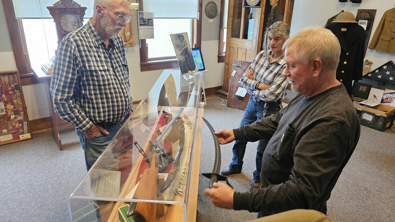 William Stocks, front, holds mountain man Jim Baker's sword up, demonstrating where it might be placed at the Little Snake River Museum, while LSR Museum board member Jim Roberts and LSR Museum Director Lela Emmons look on. Stocks has donated the sword to the museum, where it will join other Baker items on display.