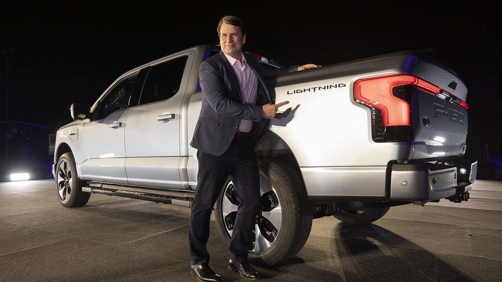 Ford CEO Jim Farley poses with one of his company's electric F-150 Lightning trucks. He said he was surprised recently when driving a Lightning himself how long it takes to charge it.