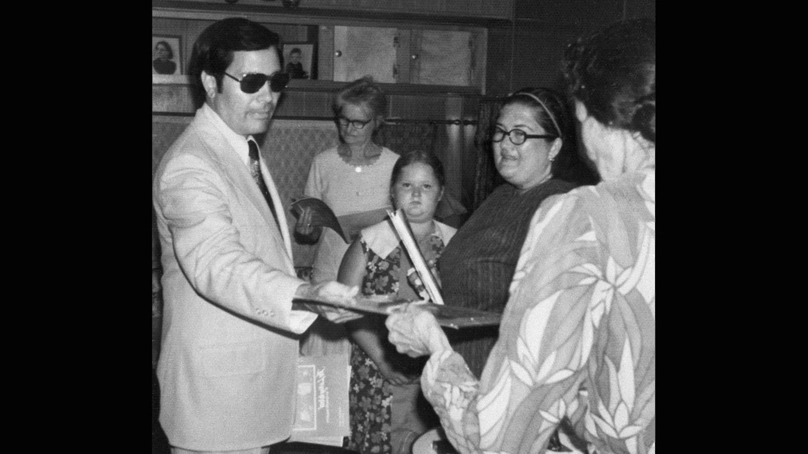 Followers gather around the Rev. Jim Jones, left. This photograph is a reproduction of one of the undated color photographs in a photo album, found among the dead in the Jonestown commune in Guyana after the mass suicide in 1978.