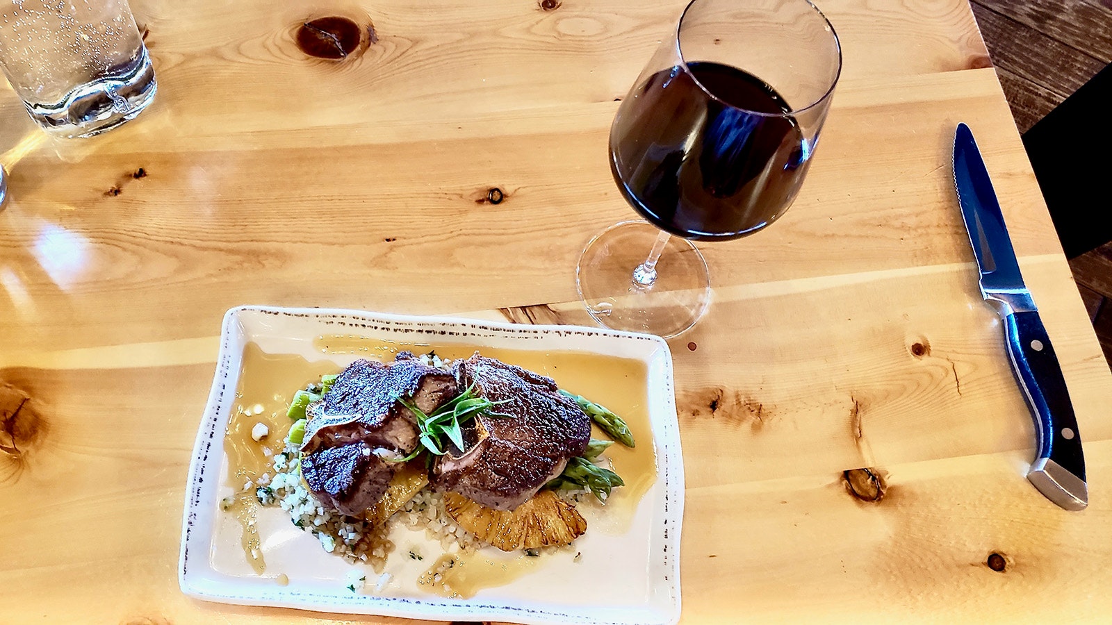 Lamb T-bone steak with cauliflower rice and Spanish wine makes a uniquely Western, yet high-end, meal at Bird and Jim in Estes Park, Colorado.