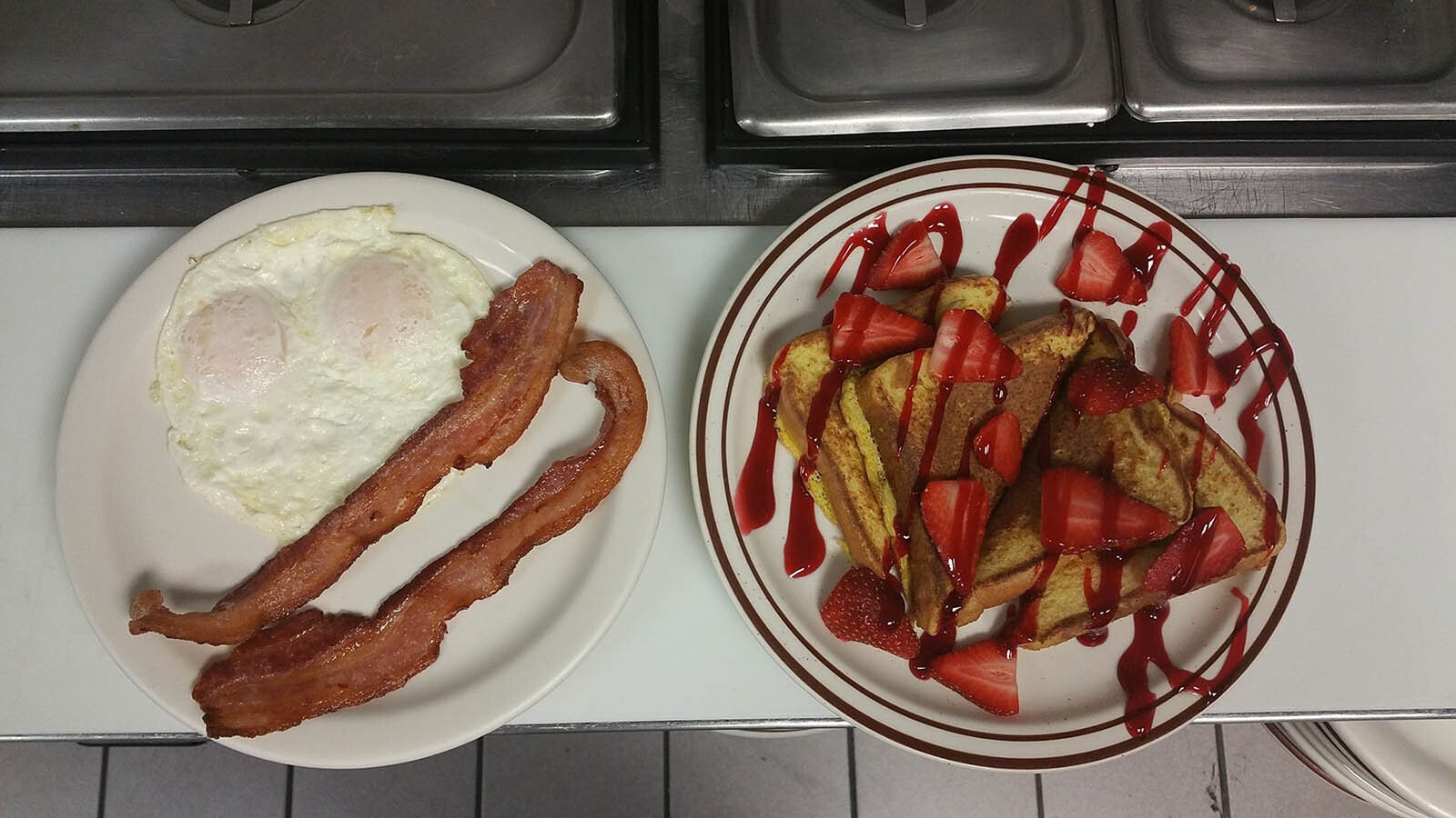 Eggs over easy with bacon and strawberry French toast.