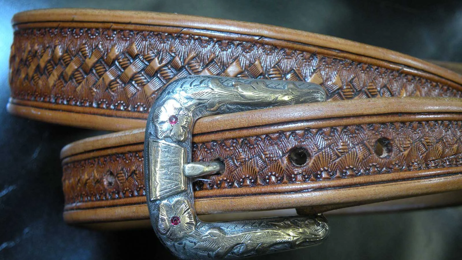 A belt with silver accents made by wyoming leatherworker and saddlemaker John L. Blair.
