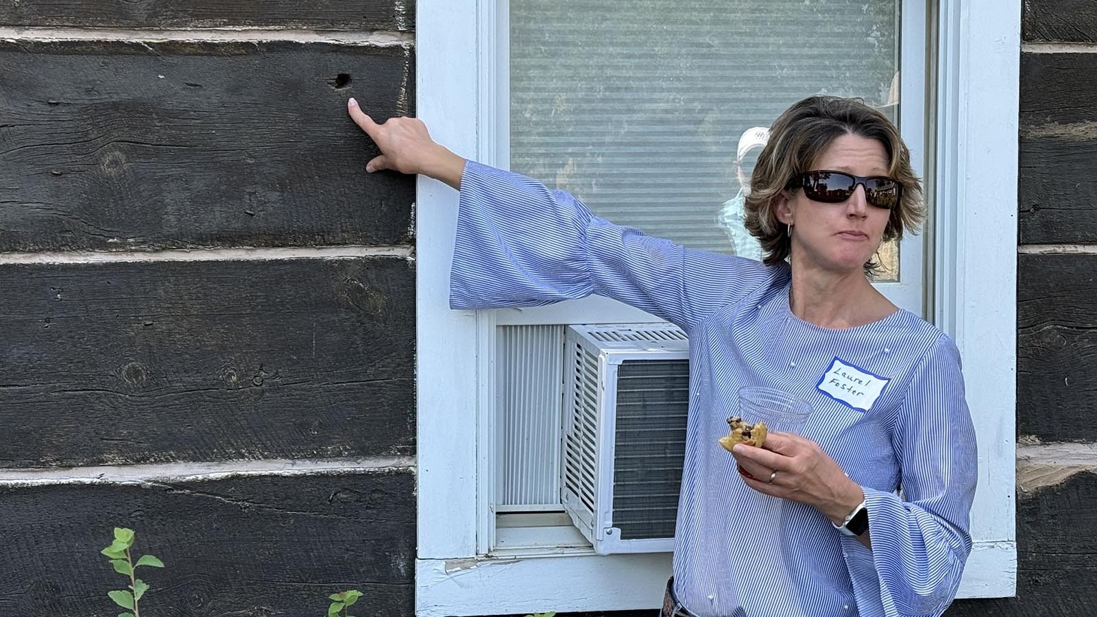 Laurel Foster, the director of the Hoofprints of the Past Museum in Kaycee, points out of the bullet holes in the wall of the ranch house on the TA Ranch. The only casualty of the three-day siege was Billy Irvine's toe, which may have been severed by the same bullet that left this hole.