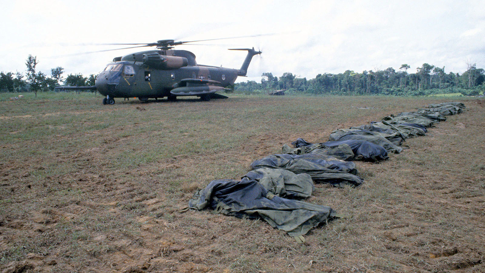 A U.S. Air Force HH 53 Jolly Green Giant helicopter from the 55th Aerospace Rescue and Recovery Squadron stands by to assist in the removal of the remains of the victims of the Jonestown tragedy in 1978.