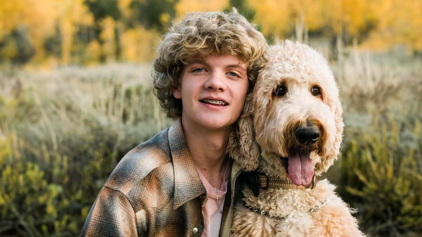 Joran Cochran smiles for a photo with his dog Apollo.