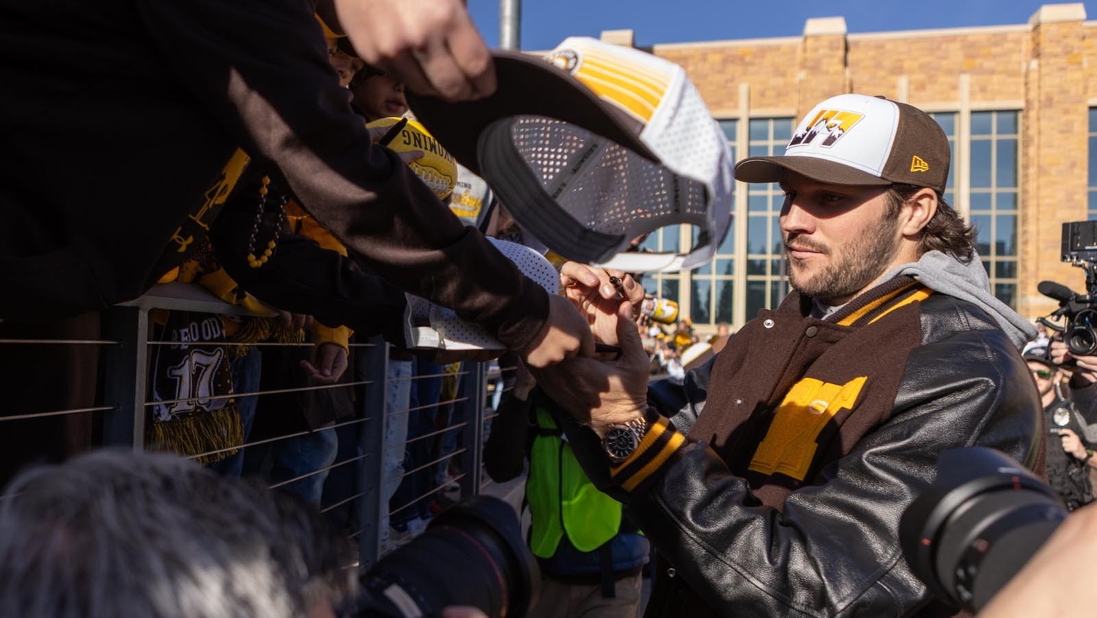 Former University of Wyoming star quarterback Josh Allen signs autographs for young fans before kickoff off the Cowboys' game against Nevada at War Memorial Statium in Laramie on Saturday, Nov. 22, 2025. Allen was back at UW for the first time since he was drafted into the NFL in 2018 to become the first UW football player to have his number retired.