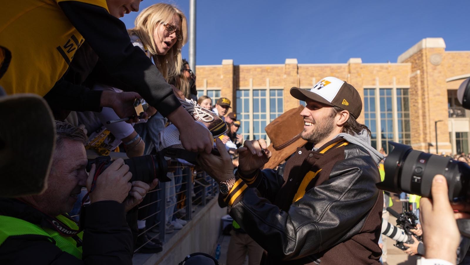 Former University of Wyoming star quarterback Josh Allen signs autographs for young fans before kickoff off the Cowboys' game against Nevada at War Memorial Statium in Laramie on Saturday, Nov. 22, 2025. Allen was back at UW for the first time since he was drafted into the NFL in 2018 to become the first UW football player to have his number retired.