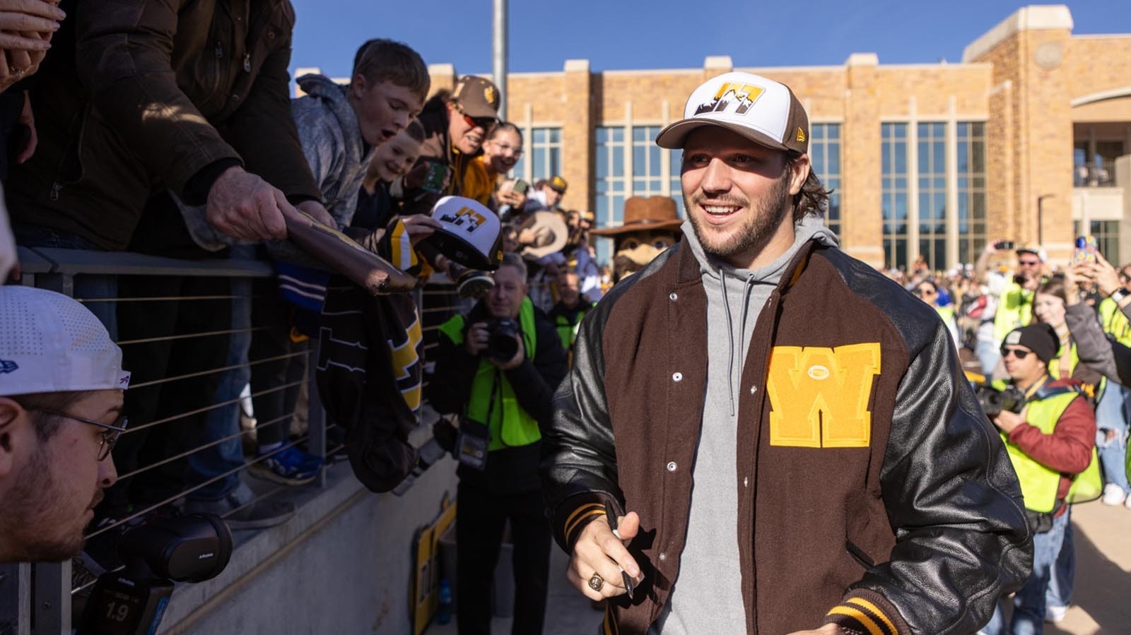Former University of Wyoming star quarterback Josh Allen signs autographs for young fans before kickoff off the Cowboys' game against Nevada at War Memorial Statium in Laramie on Saturday, Nov. 22, 2025. Allen was back at UW for the first time since he was drafted into the NFL in 2018 to become the first UW football player to have his number retired.