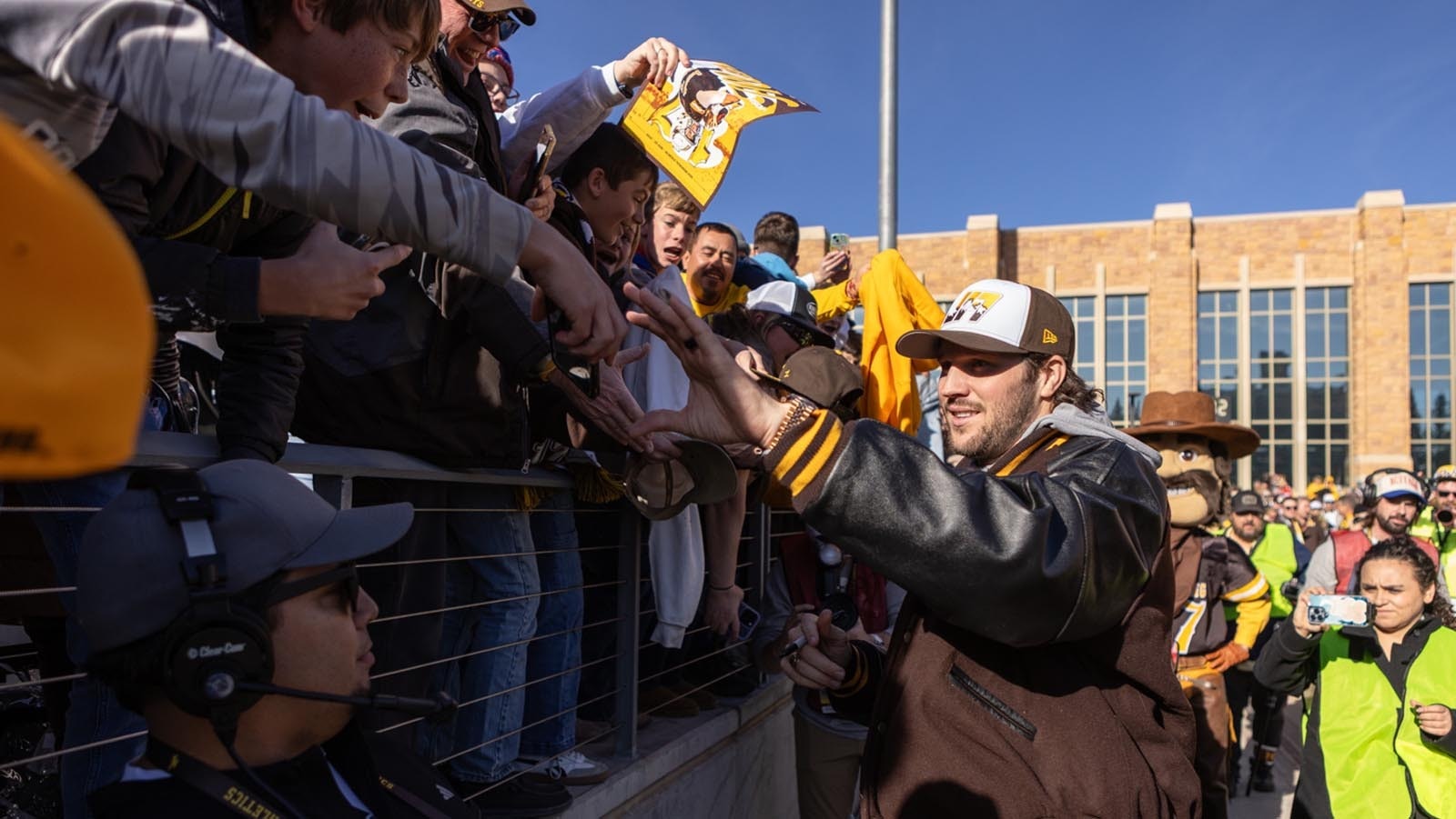 Former University of Wyoming star quarterback Josh Allen signs autographs for young fans before kickoff off the Cowboys' game against Nevada at War Memorial Statium in Laramie on Saturday, Nov. 22, 2025. Allen was back at UW for the first time since he was drafted into the NFL in 2018 to become the first UW football player to have his number retired.