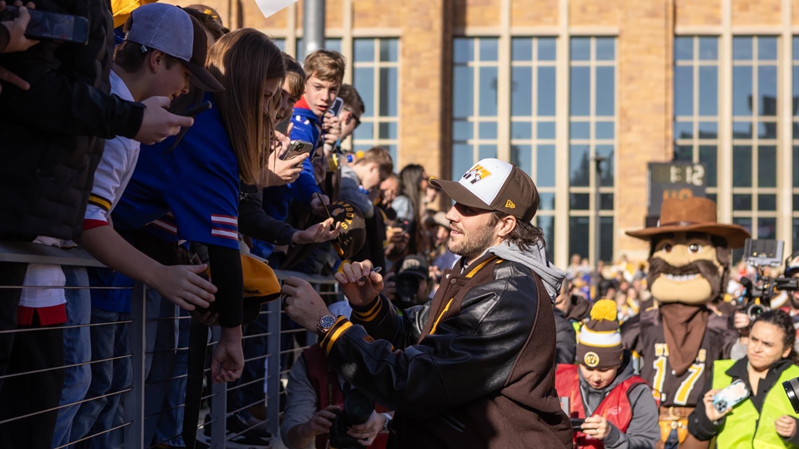 Former University of Wyoming star quarterback Josh Allen signs autographs for young fans before kickoff off the Cowboys' game against Nevada at War Memorial Statium in Laramie on Saturday, Nov. 22, 2025. Allen was back at UW for the first time since he was drafted into the NFL in 2018 to become the first UW football player to have his number retired.