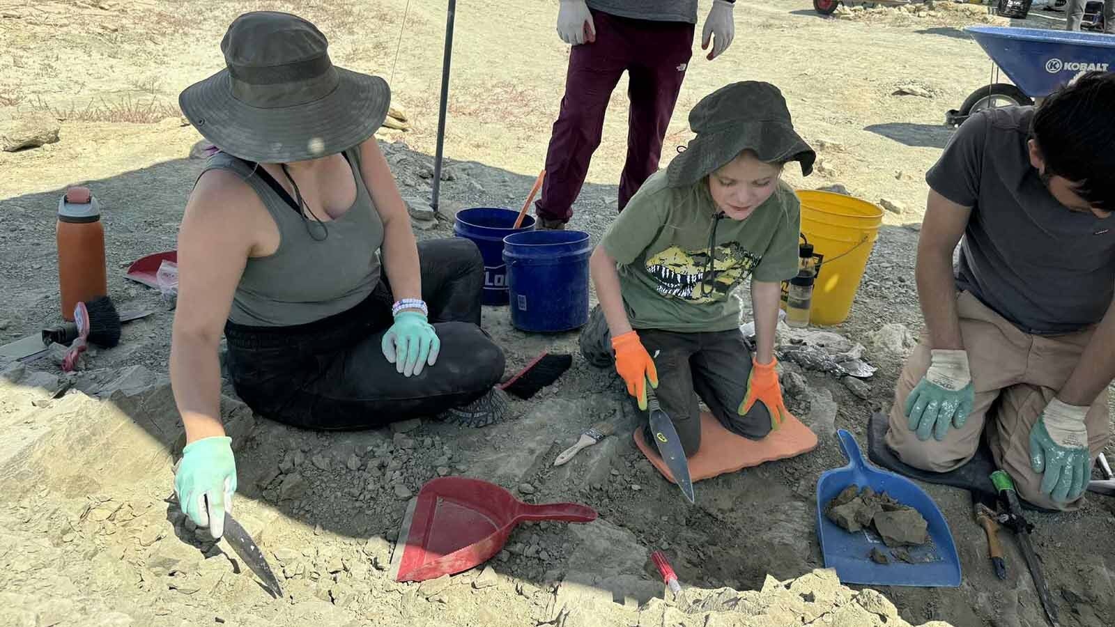 Nico and Aubrey Able slowly digging away at a layer of 145-million-year-old mudstone in the Morrison Formation exposed at the Jurassic Mile.