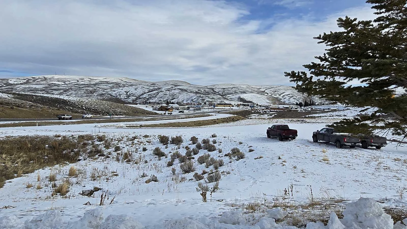 Kemmerer and Diamondville are nestled amidst the Oyster Hills, in the background. In the foreground, one of the many parking lots that appears almost empty by day, but fills up at night with work trucks.