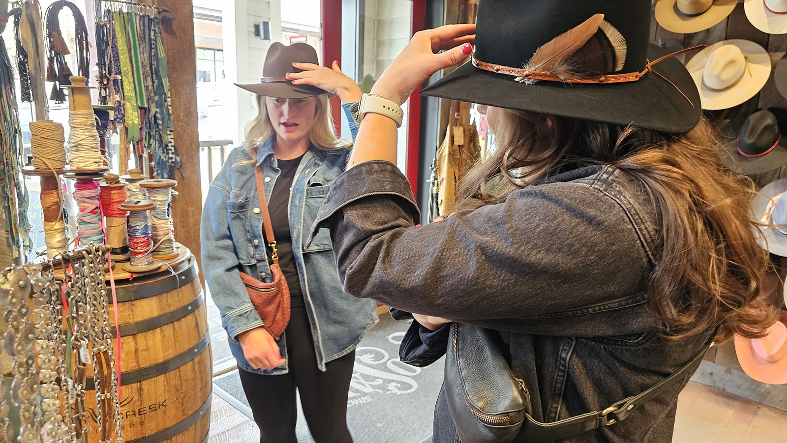 Anne Marie Cress, left, listens as her girlfriends Mary Sullivan, right, and Megan Prez (not pictured) advise her on the look of her hat.
