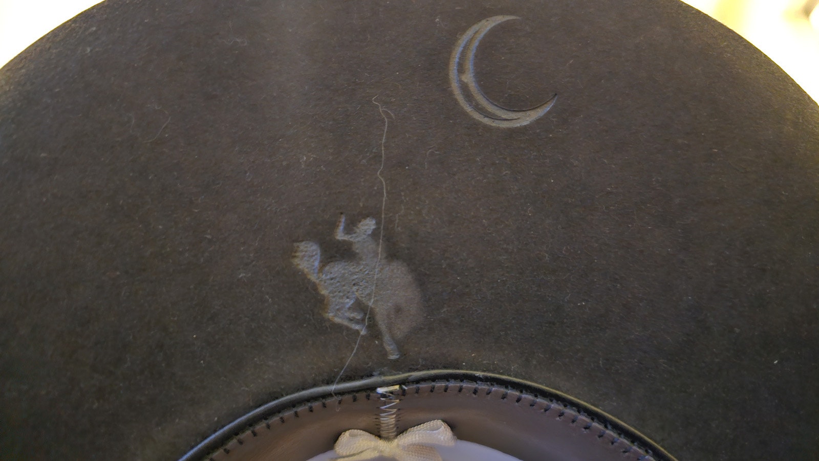 Brands can be added to the underside of the hat like this one that shows the bucking horse dancing under a moon.