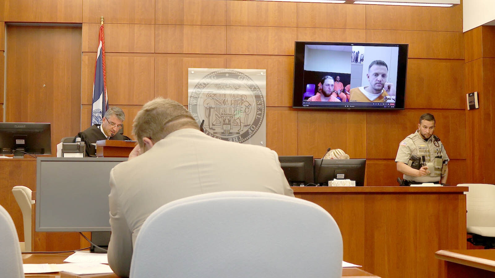 Jakob Klinger appears left on a video screen, in Casper Circuit Court Monday. He is charged with three counts of driving while under the influence with serious bodily injury.