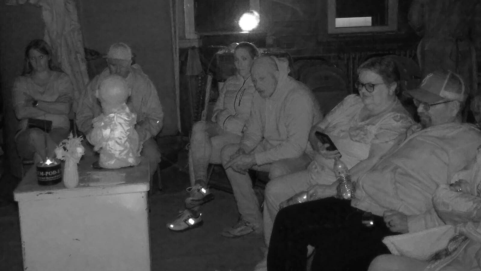 A group of paranormal investigators sit in the dark around an Ovilus doll in the basement of the Knights of Pythias building in Cheyenne. Some believe that when the doll is asked questions, it channels answers form the beyond.