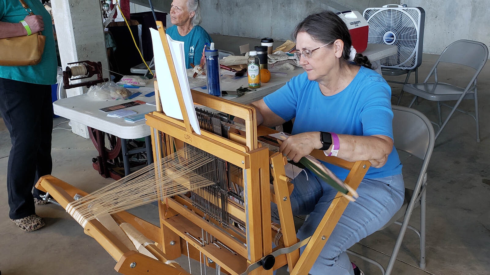 A demonstration of how to work a loom.