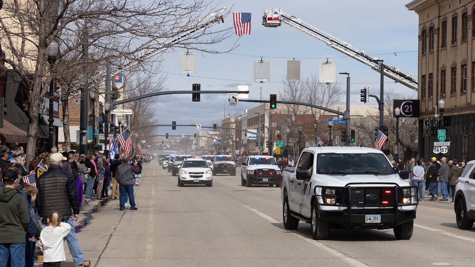 Sheridan residents line the streets downtown Friday to watch a long procession of law enforcement escort the body of Sheridan police Sgt. Nevada Krinkee and his family to a memorial service for the officer, who was killed in the line of duty Feb. 13.