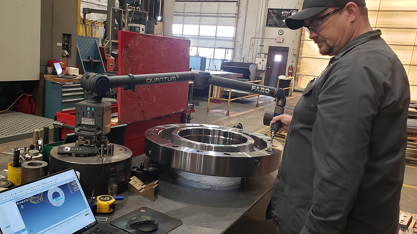 An L&H Industrial employee in Gillette, Wyoming, checks the specs on a finished part as part of a quality assurance process. L&H makes and repairs some of the largest parts known to man.