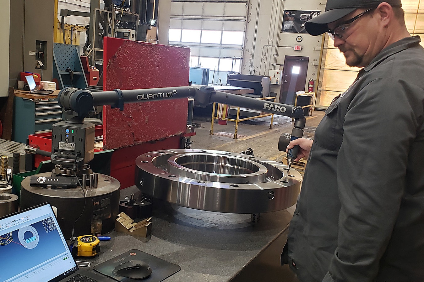 An L&H Industrial employee in Gillette, Wyoming, checks the specs on a finished part as part of a quality assurance process. L&H makes and repairs some of the largest parts known to man.