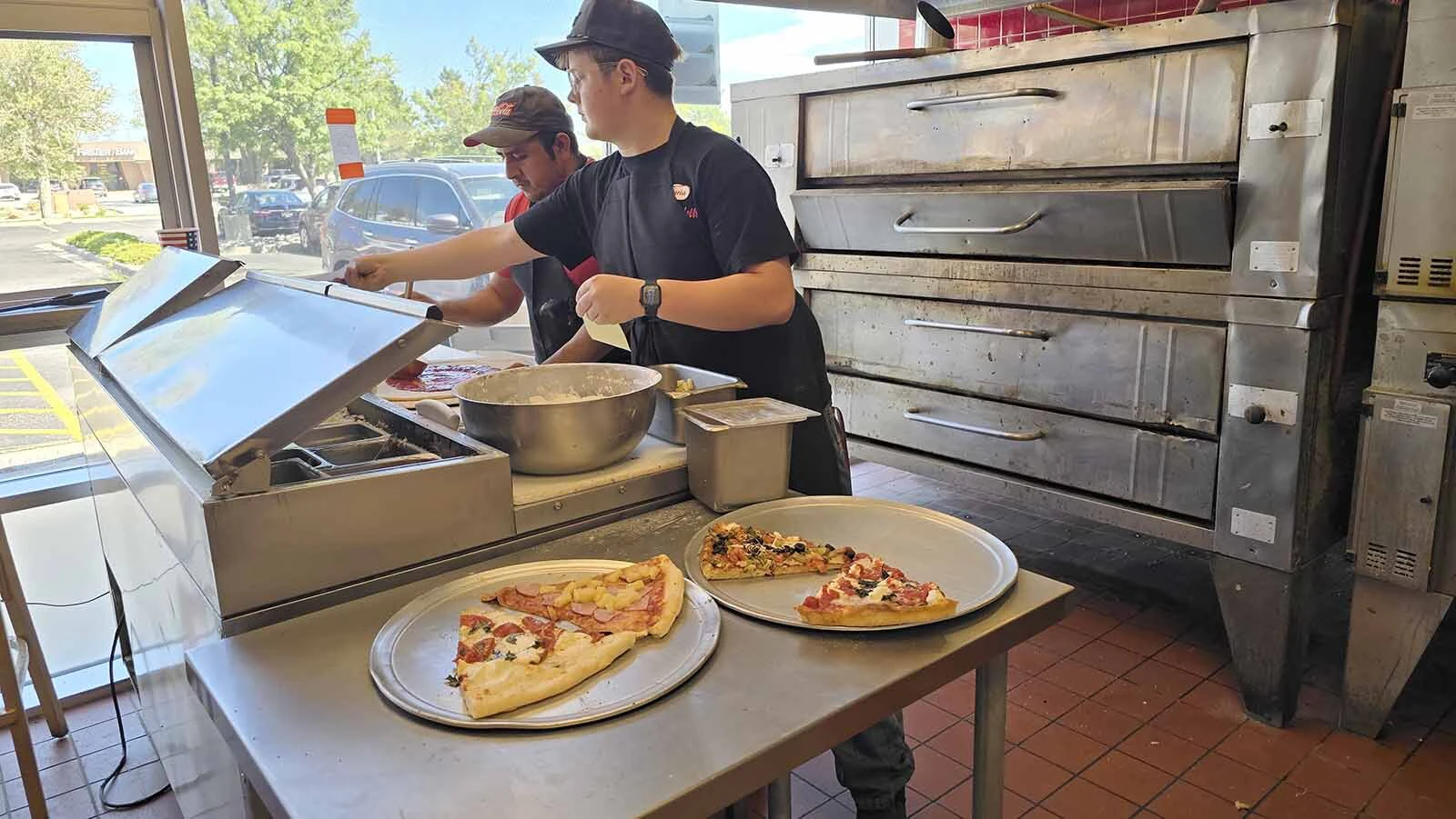 Bryce Robinett works on a pizza order at L'Osteria Mondello. He's one of several teenagers who work at the pizzaria, which has a waiting list of 17 other youths who would like to work there.