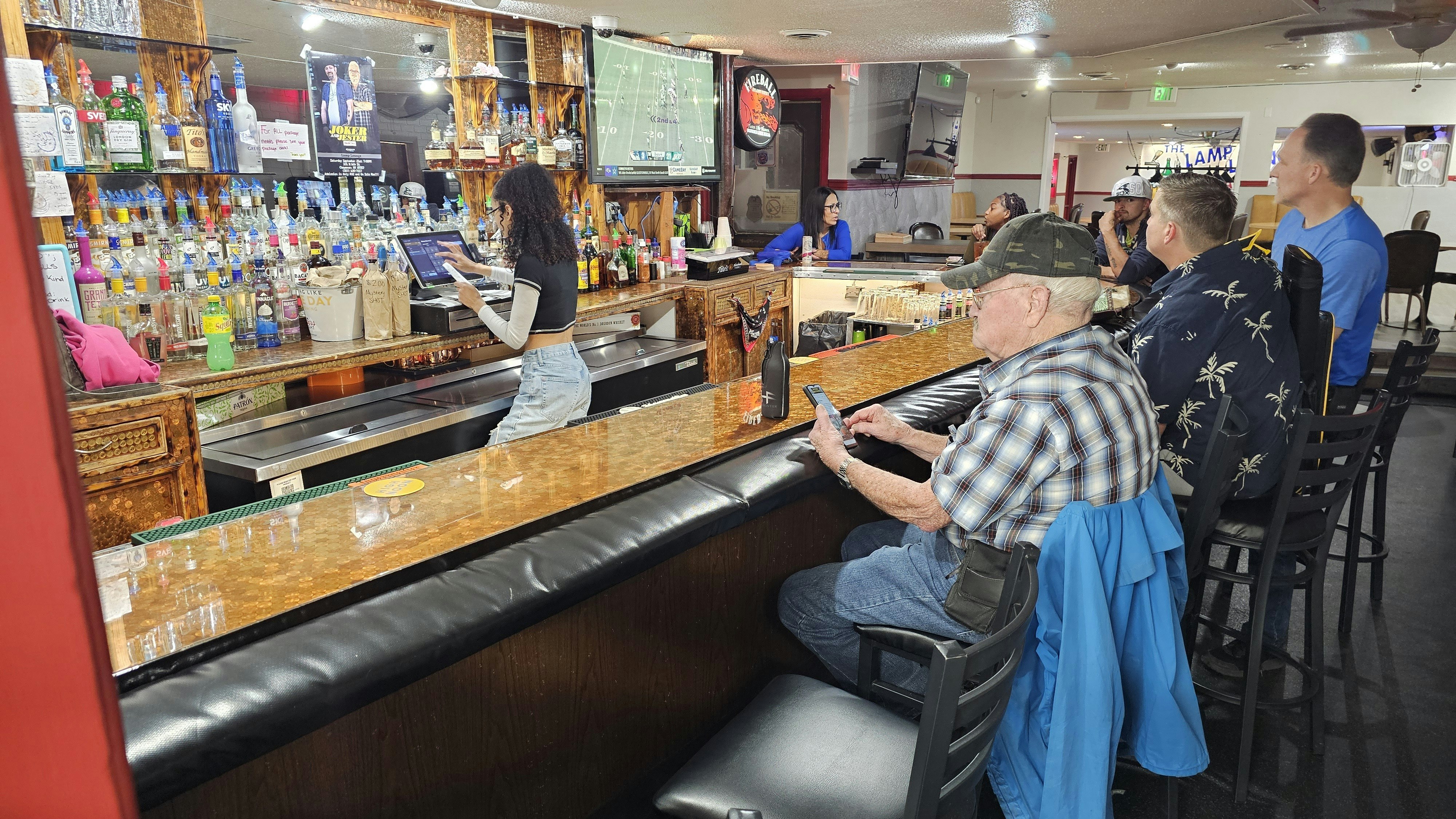 Patrons sit at the historic penny bar in the Lamp Lounge on the south side of Cheyenne