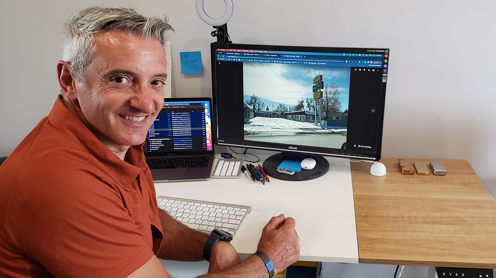 Fabian Lobera poses in front of his computer showing a photo of The Lander Motel before work started to renovate it.