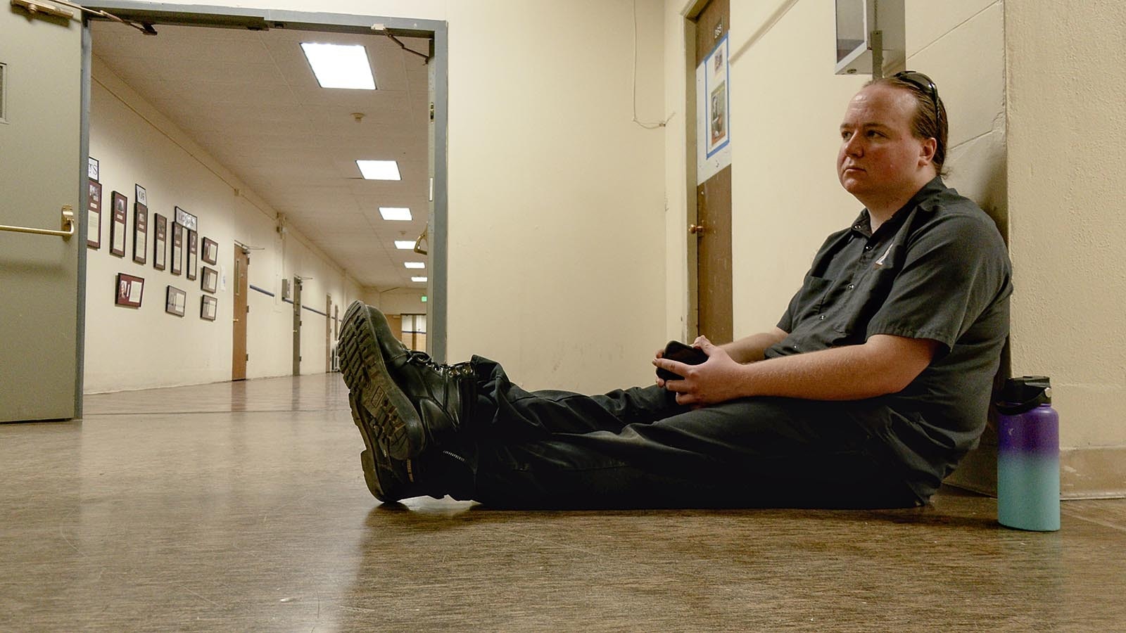 Building operations director Ben Anderson sits on the floor during a paranormal investigation of the civic center. Anderson does not believe in ghosts and provided various explanations for paranormal phenomena in the building.