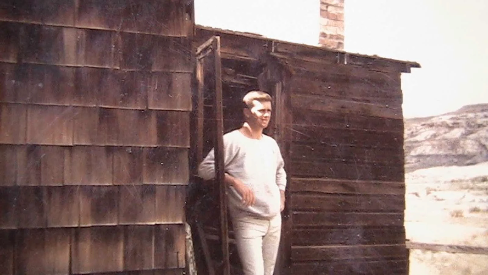 Larry Morgan stands in front of the cabin in Superior where he was born and lived until he was 4.