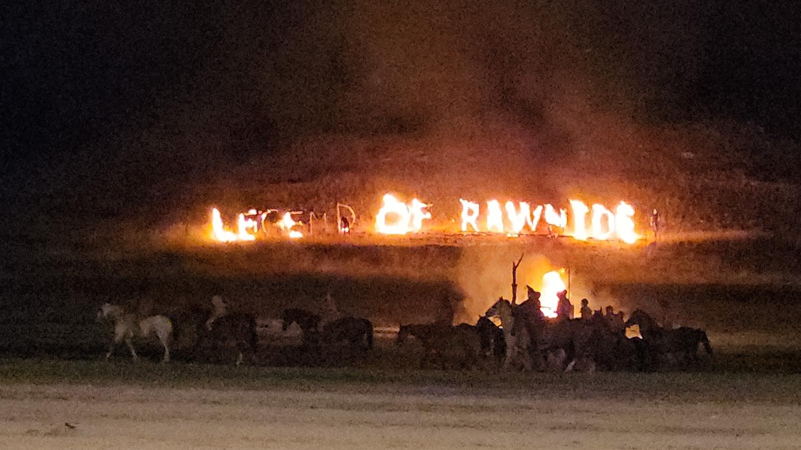 The silhouette of riders against fiery letters, Legend of Rawhide.