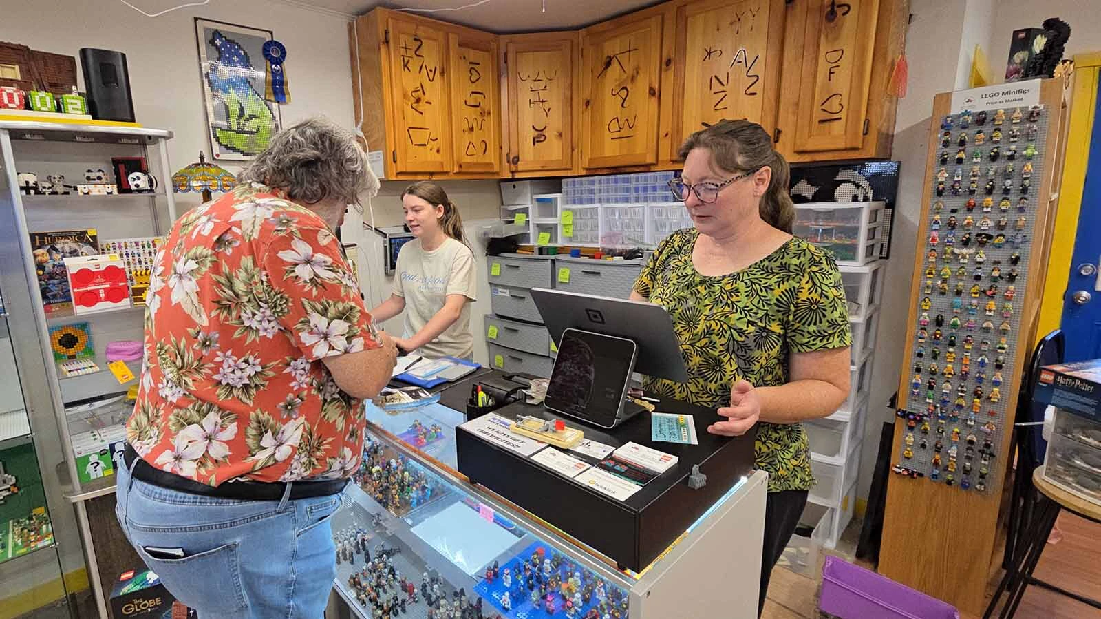 Linnea Dix, right, rings out a customer, while her daughter, Amelia, left, works on the computer.