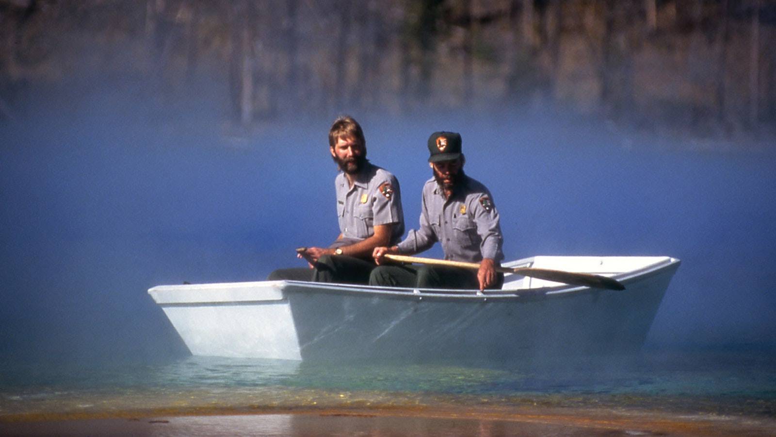 Yellowstone National Park employees Rick Hutchinson, right, and Jim Peaco guide the specially designed Little Dipper boat into the boiling waters of Grand Prismatic Spring to collect measurements of the temperature and structure of the feature in 1996.